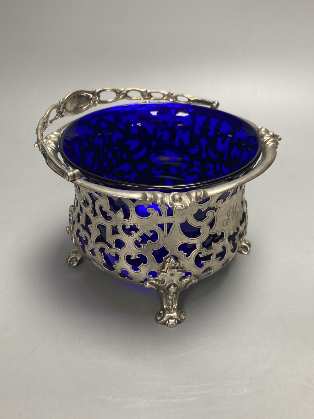 A Victorian pierced silver sugar basket with blur glass liner, George John Richards, London, 1850, height 9cm, 8oz.